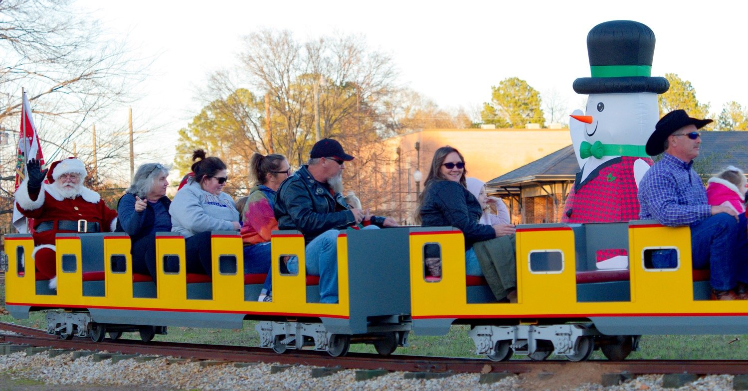 Santa brings up the caboose of the mini-train Saturday evening. [see some more of Santa's stop]